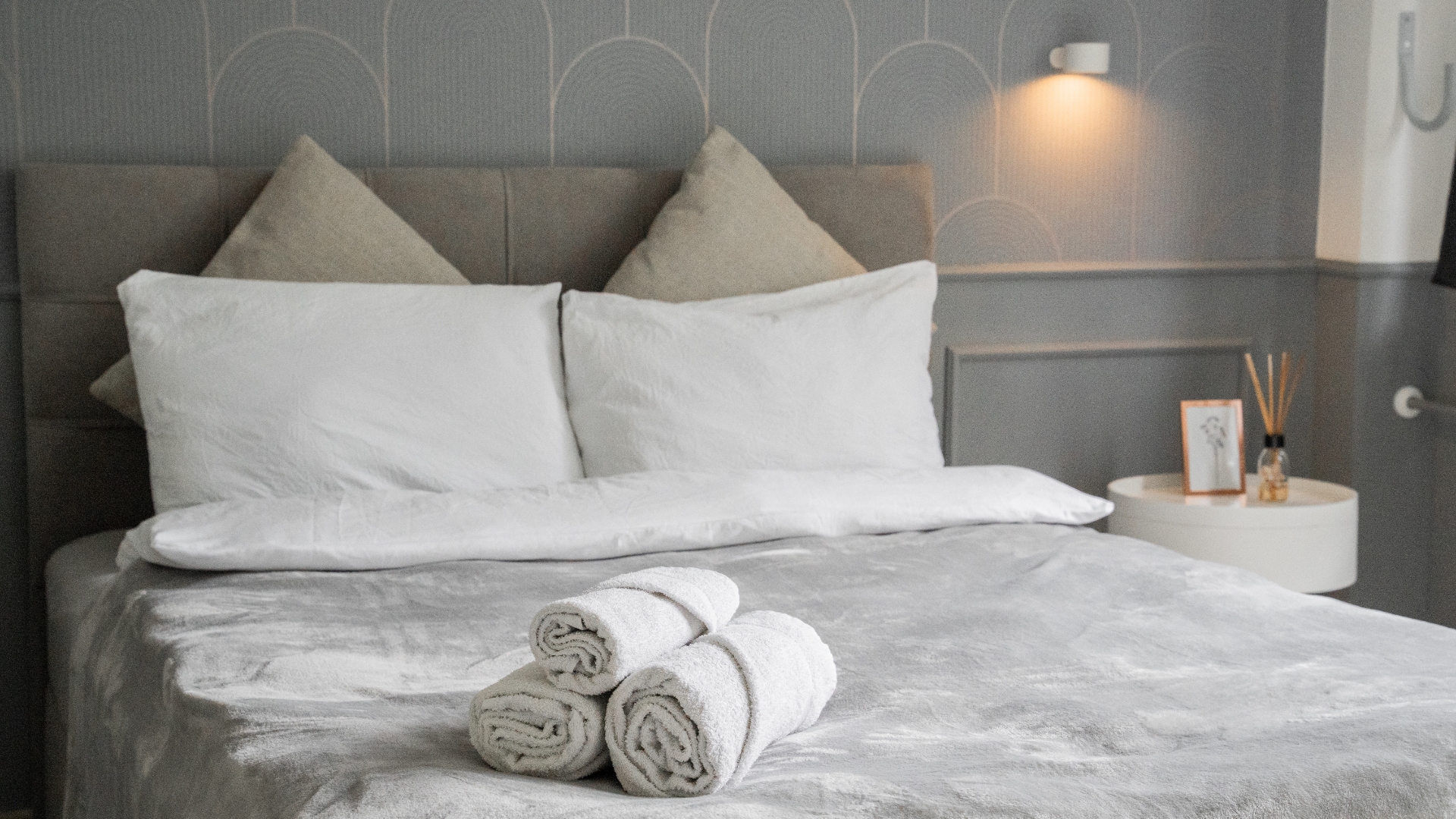 Schlafzimmer im Cozy Cologne Rentals Apartment Zentrum mit Doppelbett, frischer Bettwäsche und Handtüchern.