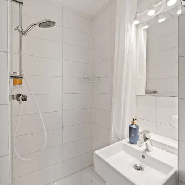 Modernes, helles Badezimmer mit Dusche und Waschbecken im Cozy Cologne Rentals Apartment am Neumarkt in Köln.