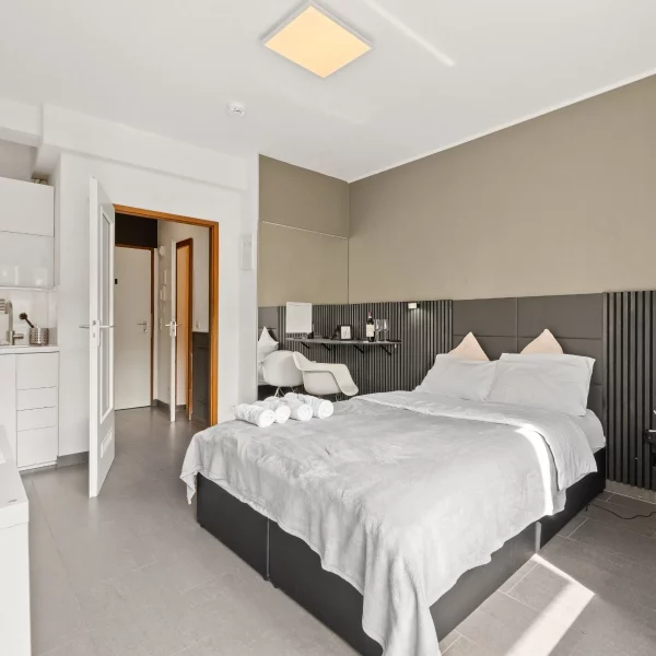 Offener Studio-Grundriss mit Schlafbereich, Kitchenette und Arbeitsnische im Cozy Cologne Rentals Apartment am Neumarkt in Köln.