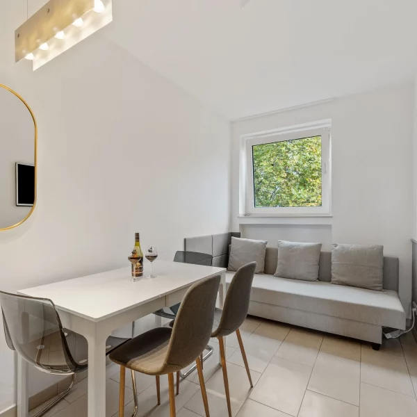 Wohn- und Essbereich in einem Cozy Cologne Rentals Apartment im Zentrum mit Esstisch, Schlafsofa und Tageslicht.