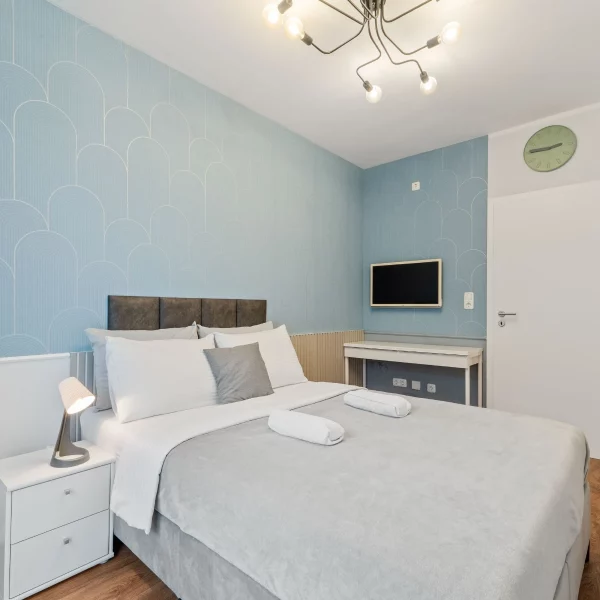 Helles Schlafzimmer mit Doppelbett in einem Cozy Cologne Rentals Apartment im Zentrum von Köln.