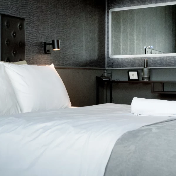 Modernes Schlafzimmer mit Doppelbett und dunkler Akzentwand in einem Cozy Cologne Rentals Apartment im Zentrum von Köln.